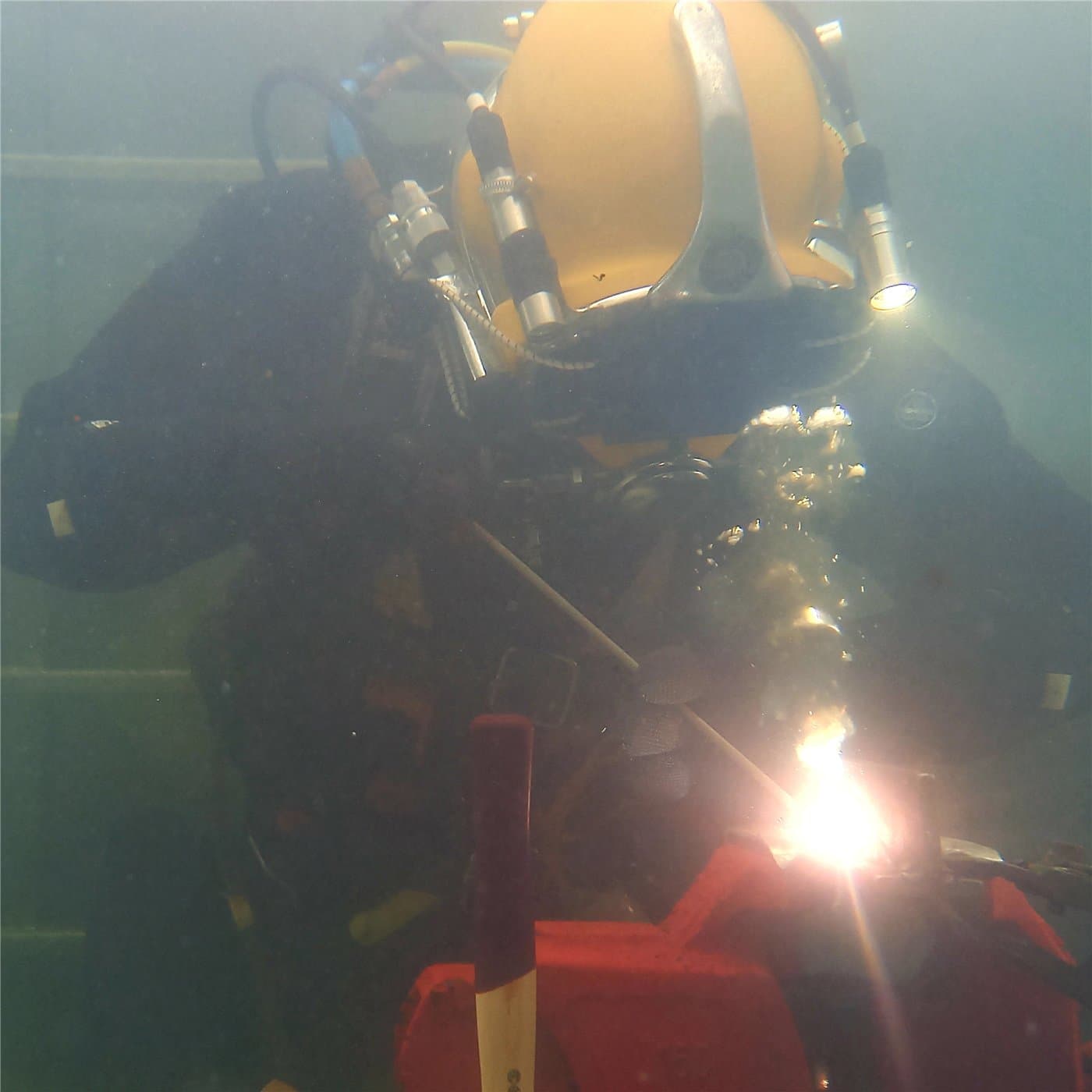 Unterwasserschweißen: Taucher schweißt mit Lichtbogen unter Wasser